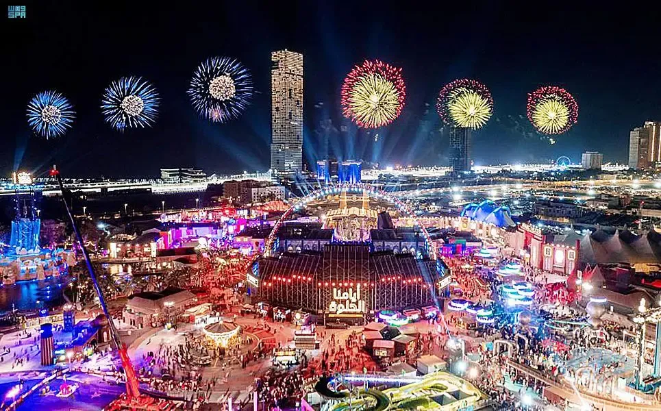 Night waterfront fairground with fireworks